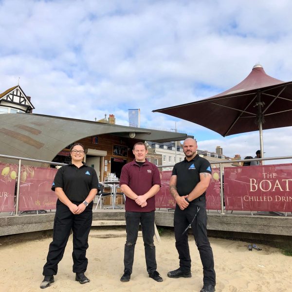 The Real World Services Team with Darren Deadman part of Weymouths Beachside community, in front of The Boat Cafe on Weymouth beach.